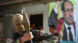 An Iraqi Shia gunman holds his RPG as he stands in front of a portrait of Iraqi Prime Minister Nouri Maliki in the Kirkuk province. Photo: 20 June 2014