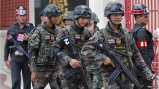 Soldiers patrol around the Royal Thai Army Headquarters as members of the Radio and Satellite Broadcasters gather in Bangkok on 18 June 2014.