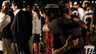 Jewish youths mourn beside the graves of the three dead teenagers 1 July 2014