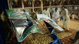Supporters of Abdullah Abdullah tear up a poster of President Hamid Karzai in Kabul (8 July 2014)