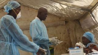 Health workers take blood samples for Ebola virus testing at a screening tent in the local government hospital in Kenema, Sierra Leone - 30 June 2014