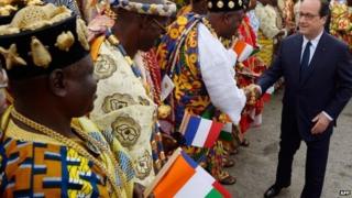French President Francois Hollande shakes hands with representatives of traditional authorities upon his arrival in Abidjan on 17 July 2014