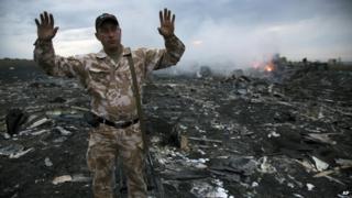 People inspect the crash site of a passenger plane near the village of Grabove, Ukraine