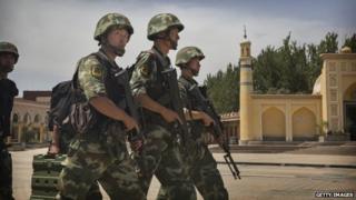 Chinese soldiers march in front of the Id Kah Mosque, China's largest, on 31 July 2014 in Kashgar, China