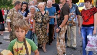 A young boy holds a loaf of bread as residents of the eastern Ukrainian city of Lysychansk queue to receive bread distributed as part of humanitarian aid on 27 July 2014.