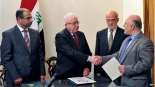 Iraqi President Fuad Masum (2nd L) shakes hands with deputy parliamentary speaker Haidar al-Abadi who has been tasked with forming a government ( image from Iraqi state TV)