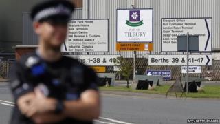 A policeman stands guard outside the entrance to Tilbury Docks