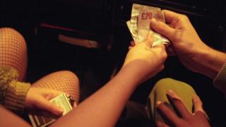 Man paying a woman