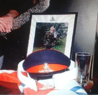 Framed picture of Andrea Martin with hat, belt and flag that have been stolen