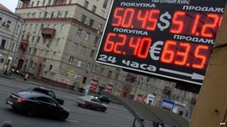 A board showing the rouble exchange rate above a street