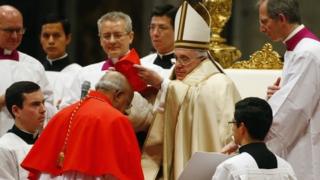 Pope Francis puts the hat on newly elevated Cardinal Berhaneyesus Demerew Souraphiel in St Peter's Basilica at the Vatican, 14 February 2015