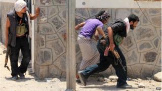 Militiamen loyal to the government take position during clashes with Houthi rebels in the Yemeni city of Aden (24 April 2015)