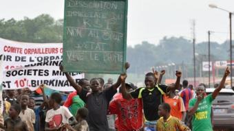 A man holds a placard that reads,