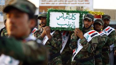 Iraqi mourners carry the coffin of a member of the Shia militia Asaib Ahl al-Haq who was reportedly killed in Syria, in Najaf (26 June 2014)