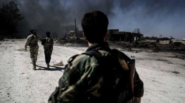 Rebel fighters from Jaysh al-Islam walk near destroyed houses in the Tal al-Siwan area of the rebel-held Damascus suburb of Douma (5 September 2016)