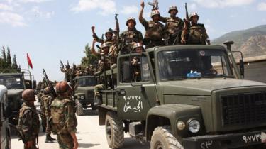 Syrian army soldiers standing on their military trucks chant slogans in support of President Bashar al-Assad, as they enter a village near the town of Jisr al-Shughour (10 June 2011)