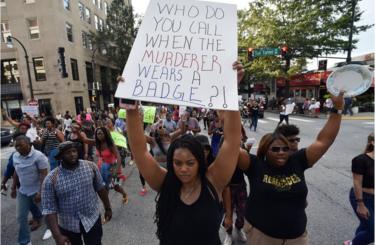 Demonstrators march through downtown Atlanta to protest the shootings of two black men by police officers, Friday, July 8, 2016