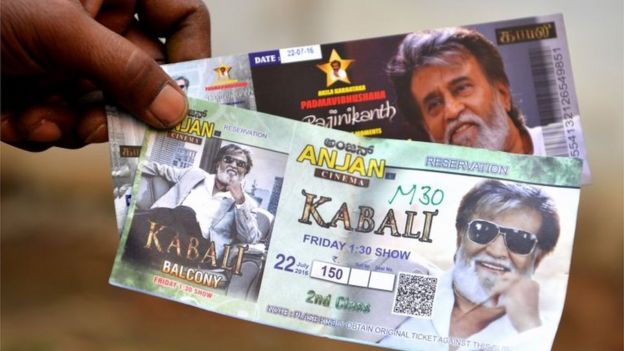 A fan shows movie tickets for Indian actor Rajinikant