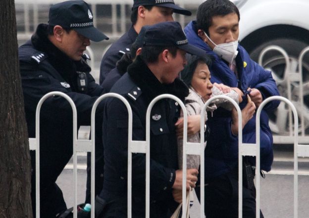 Police officers take away a supporter of rights lawyer Pu Zhiqiang near the Beijing Second Intermediate People