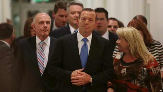 Australian Prime Minister Tony Abbott, centre, leaves the Australian Liberal Party meeting in which he lost the party leadership at Parliament House in Canberra, Monday, Sept. 14, 2015
