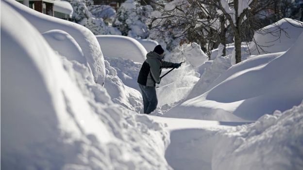 A resident shovels snow away from the entrance to his home in Union City, New Jersey, across the Hudson River from Midtown Manhattan, after the second-biggest winter storm in New York history, January 24, 2016.