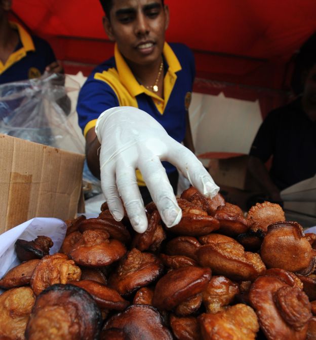 A Sri Lankan confectionary seller displays the traditional Sinhala Tamil New Year oil cake snack kevum in Colombo