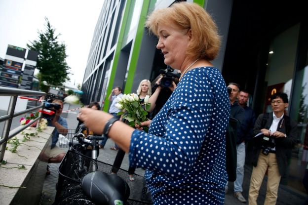 A woman lights a candle outside the Olympia shopping mall in Munich, 23 July