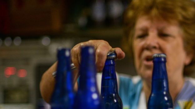 Una mujer abre unas cervezas