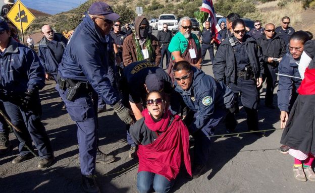 In this April 2, 2015, file photo, Department of Land and Natural Resources officers arrest a Thirty Meter Telescope protester at the telescope building site on the summit of Mauna Kea in Hilo, Hawaii