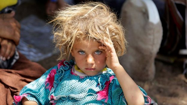Displaced Yazidi fleeing Islamic State militants in Sinjar rests at the Iraqi-Syrian border (13 August 2014)