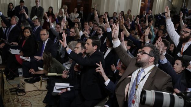 Periodistas levantando la mano.