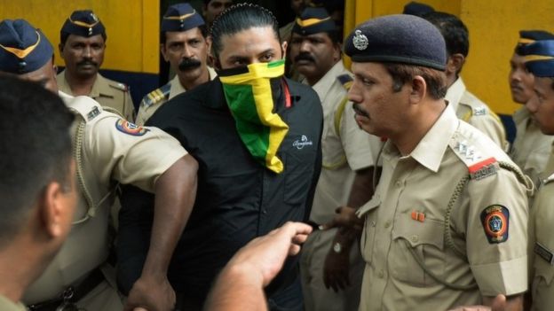 Indian police escort a suspect (C) accused of involvement in serial commuter train blasts in 2006 at a court in Mumbai on September 11, 2015