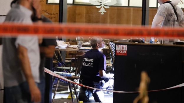 Israeli forensic police inspect a restaurant following a shooting attack at a shopping complex in Tel Aviv on June 8