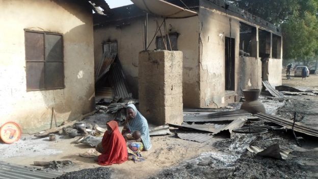 Nigerianas em frente à residência incendiada