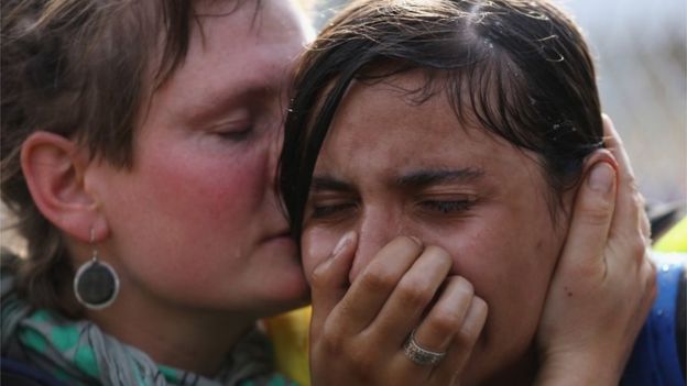 A migrant girl is comforted after being overcome by tear gas, 16 Sept