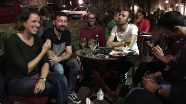 People sit around an outdoor table at a bar in Girona (4 October 2017)