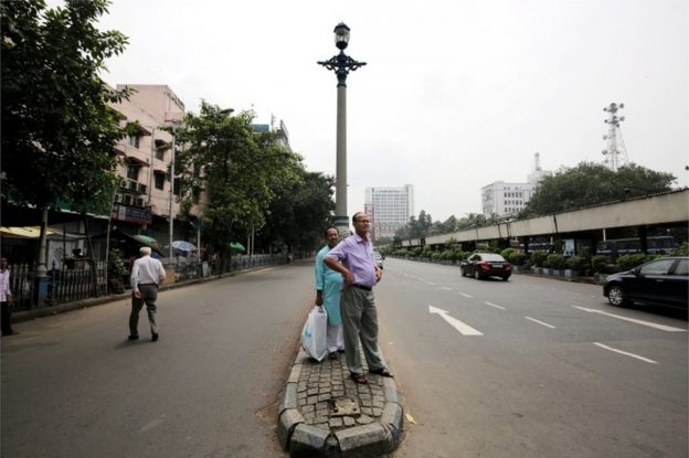 Indian passengers wait for a bus on street during nationwide general strike called by Communist Party of India (Marxist) and all trade unions in Calcutta, eastern India, 02 September 2016.