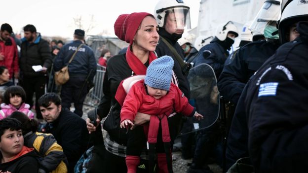 A woman looks for her husband and son as she is allowed to cross into Macedonia at the Greek-Macedonian border, near the Greek village of Idomeni. 2 March 2016