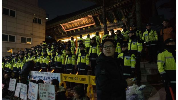 Hundreds of police officers form a cordon outside the temple compound on Wednesday night