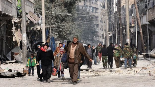 Syrian residents flee violence in Aleppo's eastern Saliheen neighbourhood on December 12, 2016 after regime troops retook the area from rebel fighters.
