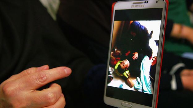 Petima, telefonundaki ölmüş eşinin fotoğrafını gösteriyor.