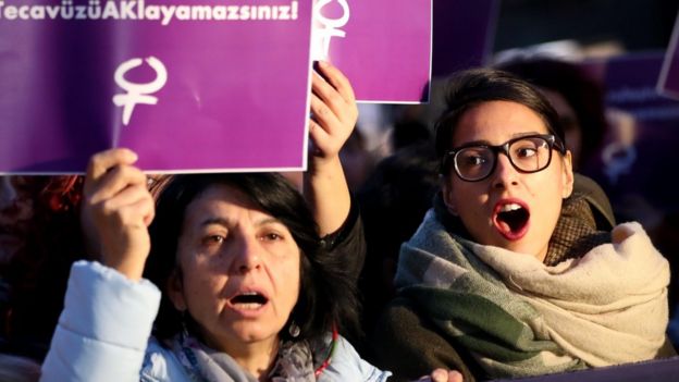 Turkish female protesters shout slogans against the government as they hold placards reading 