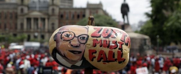 A protester holds a butternut squash painted with an image of South African President Jacob Zuma, during an anti-government march outside a court in Pretoria, South Africa, Wednesday, Nov. 2, 2016. Thousands of South Africans are demonstrating for the resignation of President Jacob Zuma, who has been enmeshed in scandals that critics say are undermining the country's democracy.