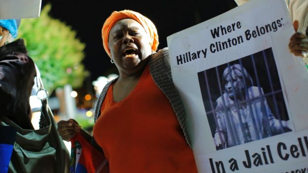 A Haitian woman holds a banner outside Hofstra University before the first presidential debate at the Hofstra University, in Hempstead, New York, on 26 September 2016