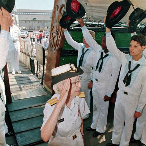 Grace Hopper haciendo el saludo militar a un grupo de cadetes navales
