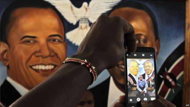A man takes a photo with his smartphone of painted artwork depicting US President Barack Obama (L) and his Kenyan counterpart Uhuru Kenyatta on July 23, 2015 at the Pre-Global Entrepreneurship Summit in Nairobi, on the eve of Obama
