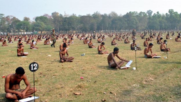 Indian army candidates sit in their underwear in a field as they take a written exam after being asked to remove their clothing to deter cheating during a recruitment day in Muzaffarpur on 28 February 2016