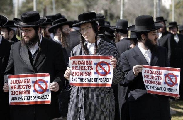 Ultra-Orthodox Jewish protestors, some of them belonging to Neturei Karta, a small faction of anti-Zionist ultra-Orthodox Jews who oppose Israel's existence, hold placards during an anti-zionist demonstration outside the US consulate in Jerusalem