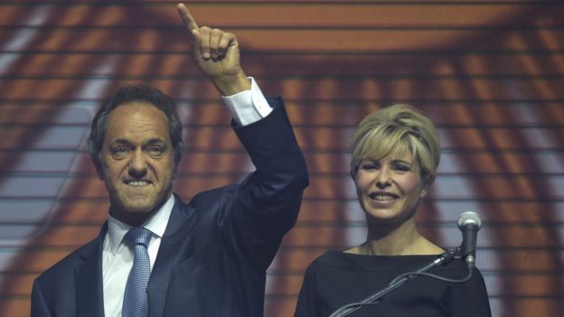 The ruling party's presidential candidate, Buenos Aires governor Daniel Scioli (L), gestures next to his wife Karina Rabolini, during the closing rally of his campaign at the Luna Park stadium in Buenos Aires, on October 22, 2015.