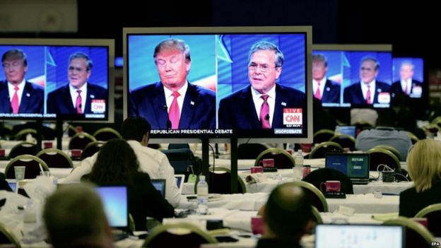 US journalists watch the debate on television monitors in the press room in Las Vegas. 15 December